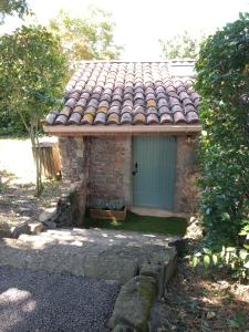 a small building with a roof with a door at Au Repos in Tréziers