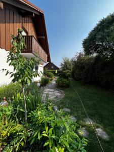 einen Garten neben einem Haus mit Balkon in der Unterkunft Zimmer zum Wohlfühlen in Eching