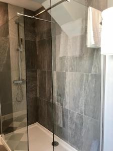 a shower with a glass door in a bathroom at Acorn Cottage in Ollerton