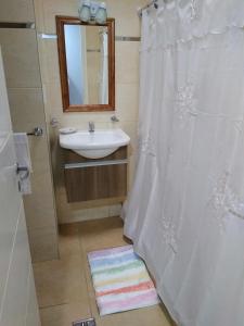 a bathroom with a sink and a shower curtain at Antonia in Guaymallen