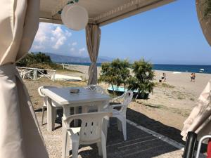 - une table et des chaises dans une tente sur la plage dans l'établissement Stella Marina, à Terme Vigliatore
