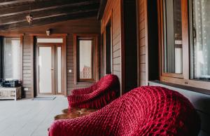 sala de estar con sofá rojo y ventanas en Pensiunea Suzanne Băile Figa en Beclean