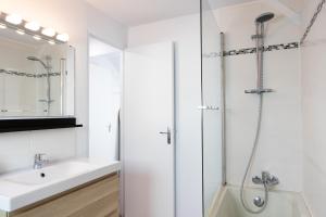 une salle de bain blanche avec une douche et un lavabo dans l'établissement Duplex T3 moderne et lumineux Angers, à Angers