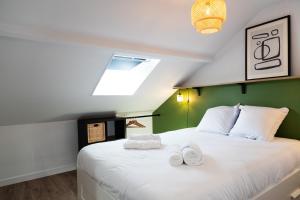 une chambre avec un grand lit blanc avec des serviettes dessus dans l'établissement Duplex T3 moderne et lumineux Angers, à Angers