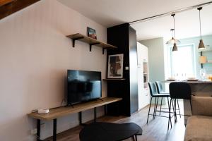 - un salon avec une télévision et une table avec une télévision dans l'établissement Duplex T3 moderne et lumineux Angers, à Angers