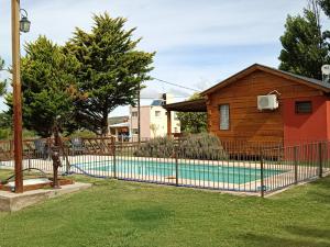 una valla alrededor de una piscina frente a una casa en Cabañas La Deolinda in 