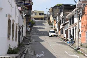 un pequeño coche blanco conduciendo por una calle con edificios en Apartamento en Cali, en Cali