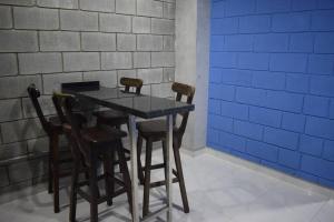 uma mesa de jantar com 4 cadeiras e uma parede azul em Apartamento en Cali em Cali