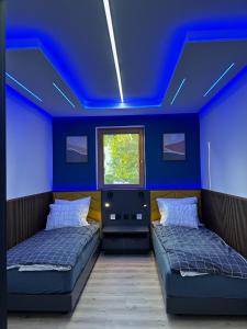 2 camas en una habitación con techo azul en Apartament Family w Czeladzi, FV, 8km do Katowic, en Czeladź