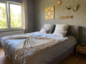 een slaapkamer met een groot bed met kussens erop bij La Villa Wellness in Hastière-par-delà