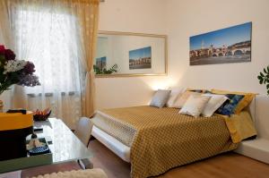 a bedroom with a bed and a table and a window at Arena d'Intorno in Verona