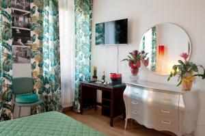 - une chambre avec un miroir, une commode et un lit dans l'établissement Arena d'Intorno, à Vérone