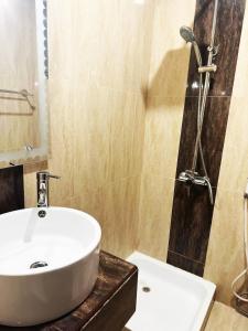 a bathroom with a white sink and a shower at Hotel Leaders Plaza Salmiya in Kuwait