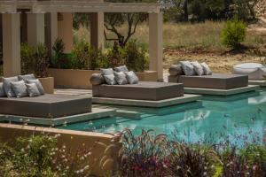 two couches sitting next to a swimming pool at Thalassa Boutique Hotel - Adults Only in Lassi