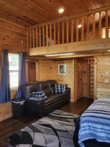 a living room with a leather couch in a log cabin at Grandpa's Cabin in Apple Valley