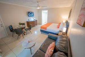 博卡拉頓的住宿－Boca Plaza，酒店客房配有床、沙发和桌子。