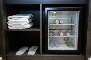 an open refrigerator with towels and clocks in it at Bee Hotel in Vlorë