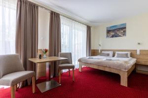 um quarto de hotel com uma cama, uma mesa e cadeiras em KIWI Sopot Apartments em Sopot