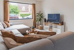 a living room with a couch and a tv at Villa Dianga (De Haan) in De Haan