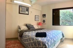 - une chambre avec un lit doté d'une couette bleue et d'une fenêtre dans l'établissement White Rose, at Carter Road by Connekt Homes, à Mumbai
