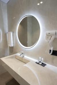 a bathroom with a sink and a mirror at Bee Hotel in Vlorë