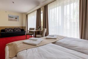 a hotel room with a large bed with towels on it at KIWI Sopot Apartments in Sopot