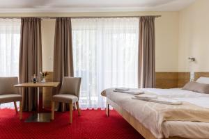 Habitación de hotel con cama, mesa y sillas en KIWI Sopot Apartments, en Sopot