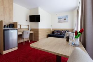 a living room with a table and a couch at KIWI Sopot Apartments in Sopot