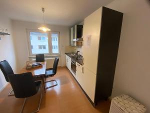 a small kitchen with a table and a refrigerator at Sali - E8 - WLAN, Self Check-In, 8PAX in Essen