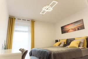 a bedroom with a bed with yellow pillows at Apartment Centro - YOUR 2nd HOME in GRAZ in Graz