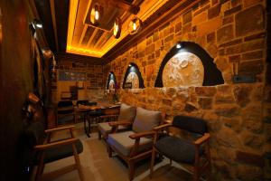 a restaurant with chairs and a stone wall at Moonlight of Cappadocia in Uchisar