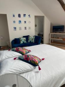 - une chambre avec 2 lits et un canapé bleu dans l'établissement Amaryllis aux Bords de Loire, à Les Rosiers