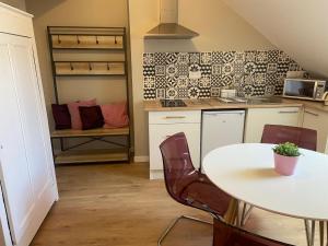 - une cuisine avec une table, une table et des chaises dans l'établissement Amaryllis aux Bords de Loire, à Les Rosiers