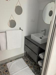 La salle de bains est pourvue d'un lavabo et de deux miroirs. dans l'établissement Amaryllis aux Bords de Loire, à Les Rosiers