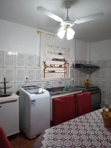 a kitchen with a table and a ceiling fan at Apartamento das Azaléias térreo in Novo Hamburgo