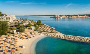 an aerial view of a beach with umbrellas and the water at Boutique Hotel Mauro in Poreč