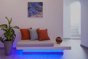 a couch sitting in a room with a potted plant at Kouros Village Hotel - Adults Only in Perissa