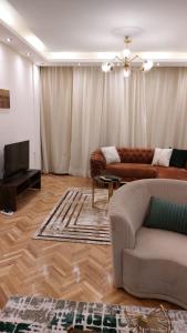 sala de estar con sofá y TV en Furnished luxury apartment, en El Cairo