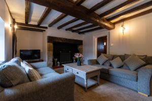 a living room with two couches and a fireplace at Bewdley River Cottage - Free private gated parking for 2 cars - River front location in Bewdley