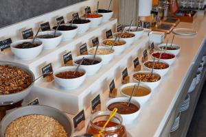 a buffet line of bowls of food on display at Kouros Village Hotel - Adults Only in Perissa