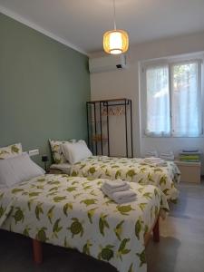 een slaapkamer met 2 bedden met gele en groene lakens bij Casa L'agrumeto in Ventimiglia