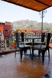 a table and chairs on a balcony with a view at Lofts Las Cuatro Puertas in Guanajuato