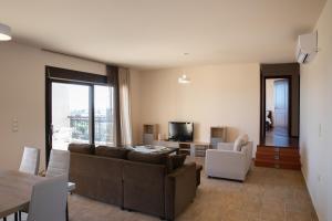 a living room with a couch and chairs and a television at Villa Panoramica in Pylíon