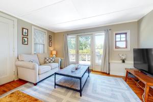 a living room with a couch and a table and a tv at Black Cove Cottage in Manchester