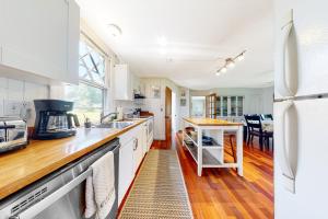 a kitchen with a sink and a refrigerator at Black Cove Cottage in Manchester
