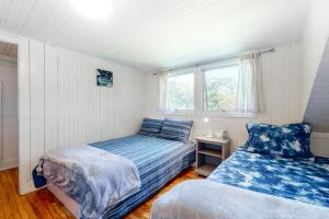 a bedroom with two beds and a window at Black Cove Cottage in Manchester