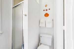 a white bathroom with a toilet and a shower at Black Cove Cottage in Manchester +14 photos