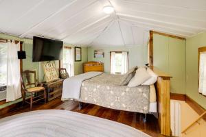 1 dormitorio con 1 cama y TV de pantalla plana en Peaceful Fishermans Paradise with Deck and Fire Pit!, en Winthrop