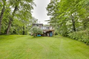 a house in the middle of a field with trees at Peaceful Fishermans Paradise with Deck and Fire Pit! in Winthrop