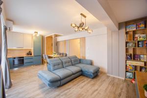 a living room with a blue couch and a kitchen at Charming Family Haven in Oradea